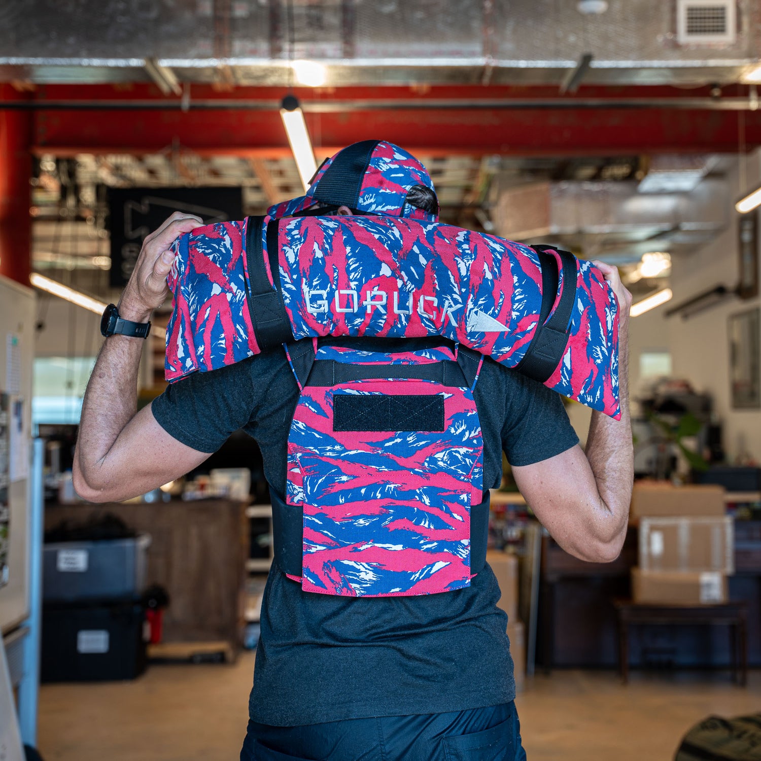 A person indoors wears a colorful life jacket labeled 