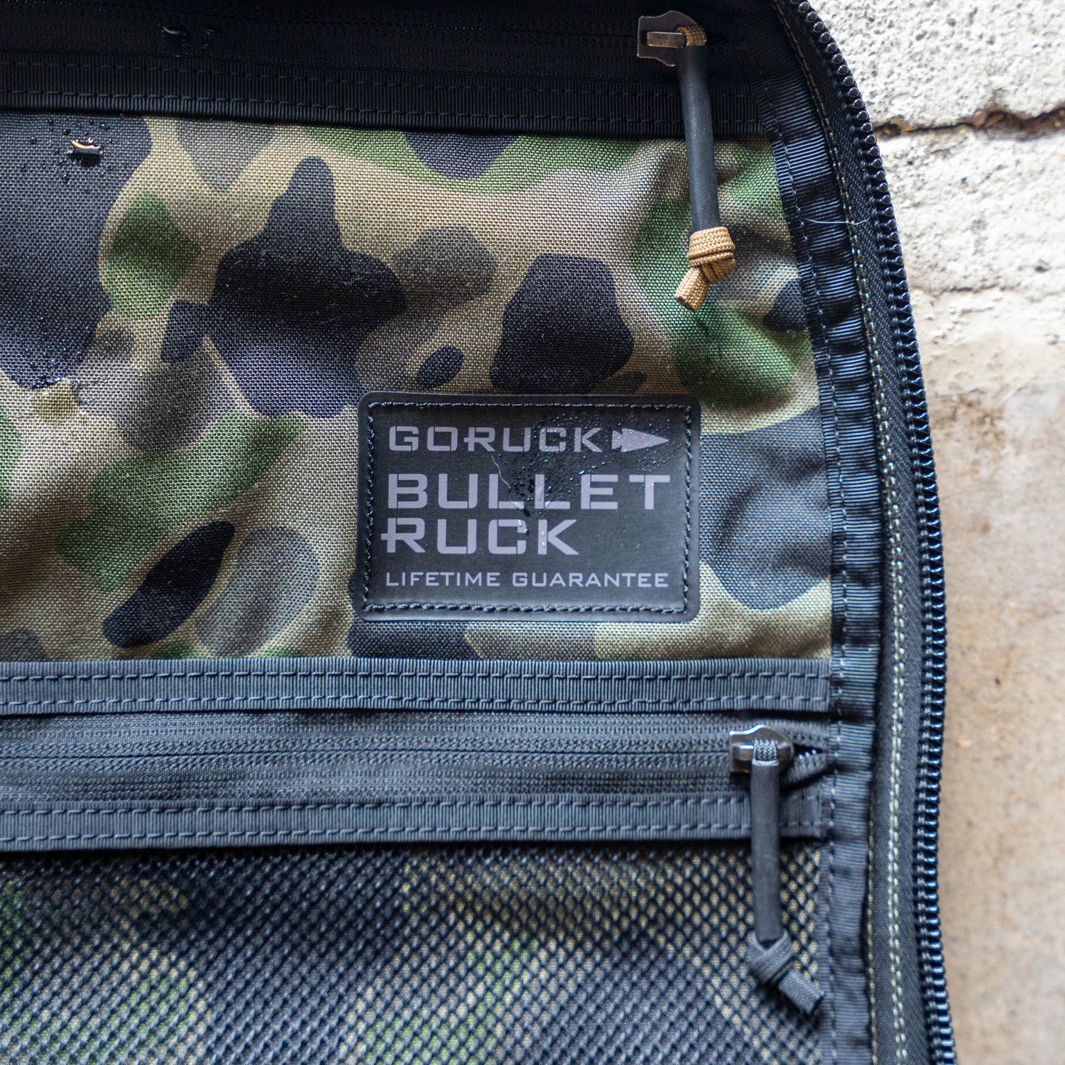 Close-up of a camo-patterned Bullet Ruck Classic - Ballistic Nylon Cordura daypack, featuring mesh pockets and a visible zipper—an ideal compact backpack for day hikes.