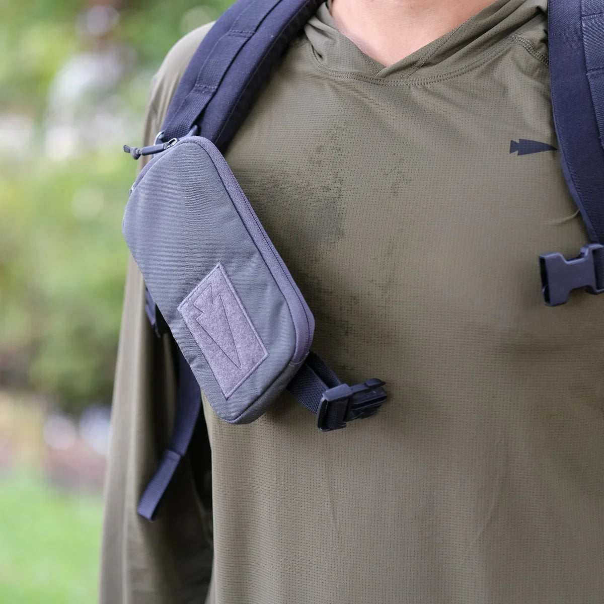 GORUCK rucksack with tactical shoulder pouch on olive green shirt outdoors