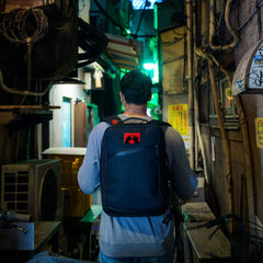 Man with GORUCK rucksack walking through urban alley at night, rugged outdoor gear