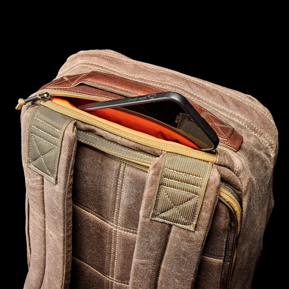 GORUCK dark oak rucksack with padded straps and zippered pocket, phone partially visible