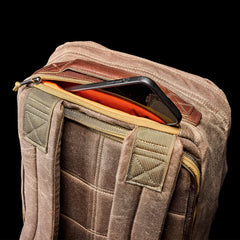 GORUCK dark oak rucksack with padded straps and zippered pocket, phone partially visible