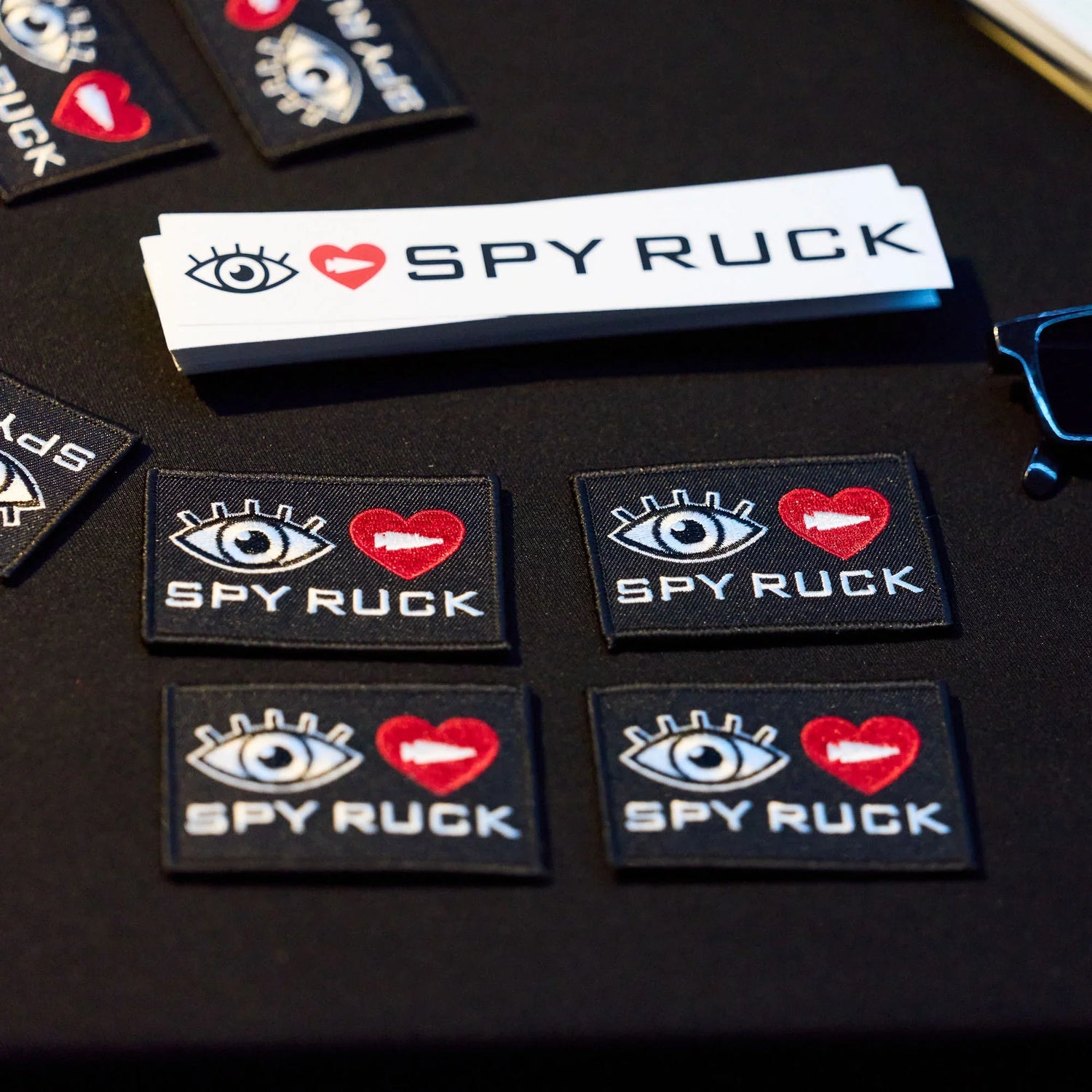 GORUCK SPY RUCK event patches and stickers with eye and heart arrow logo on black table