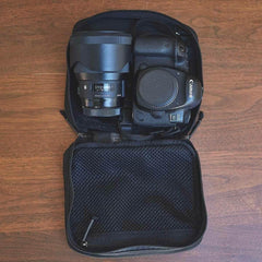 GORUCK black camera case with Canon EOS DSLR and Sigma lens on wooden surface