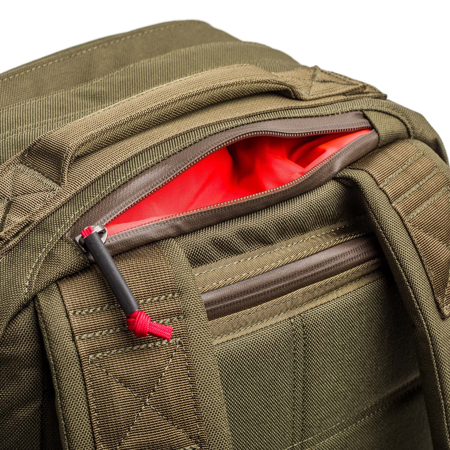 Close-up of an olive green GR2 - Cordura ruck with a partially open zipper revealing a bright red interior pocket—the ideal Special Forces carry-on travel backpack.