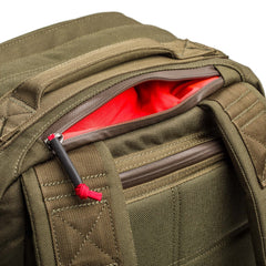 Close-up of an olive green GR2 - Cordura ruck with a partially open zipper revealing a bright red interior pocket—the ideal Special Forces carry-on travel backpack.