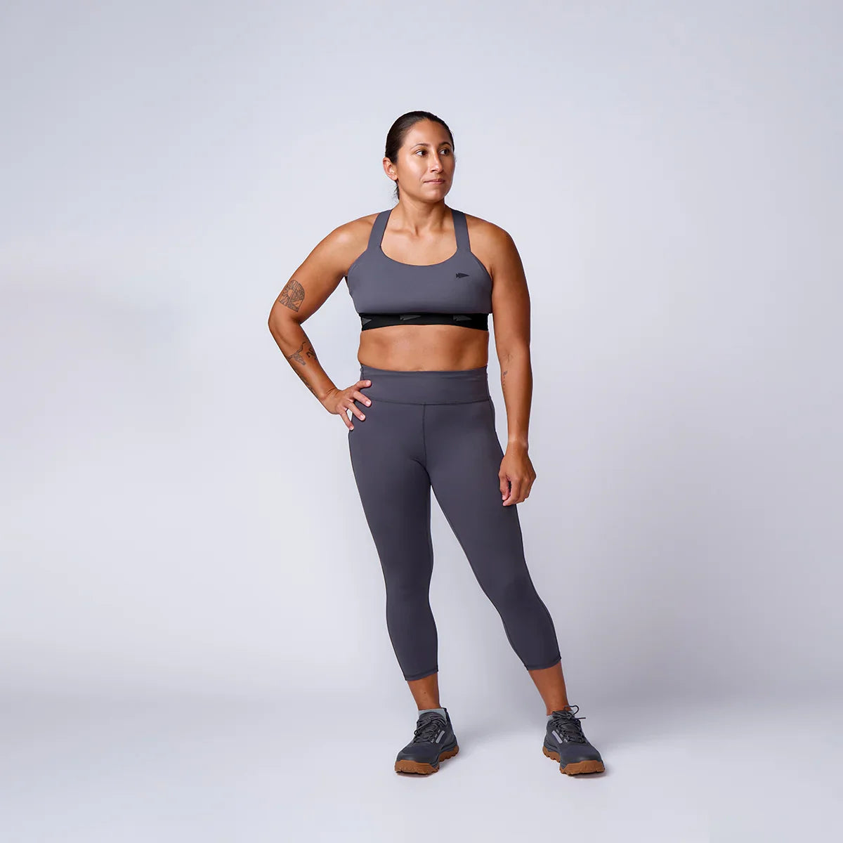 Woman in GORUCK athletic wear, gray sports bra and leggings, studio rucking gear promo