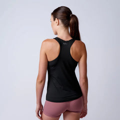 Woman wearing GORUCK black athletic tank top and mauve shorts, back view, studio setting