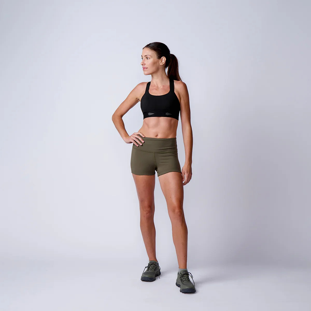Woman in GORUCK rucking gear, wearing olive shorts, black sports bra, and athletic shoes