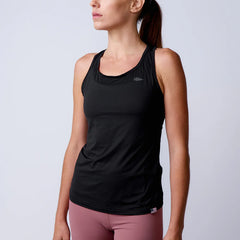 Woman wearing GORUCK black athletic tank top and pink leggings in studio setting