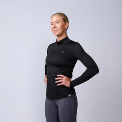 Woman wearing GORUCK black long sleeve rucking shirt and gray leggings on white background