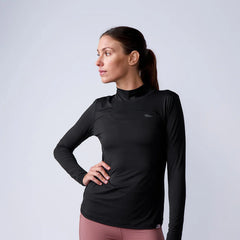 Woman wearing GORUCK black long sleeve rucking shirt and pink leggings, studio background