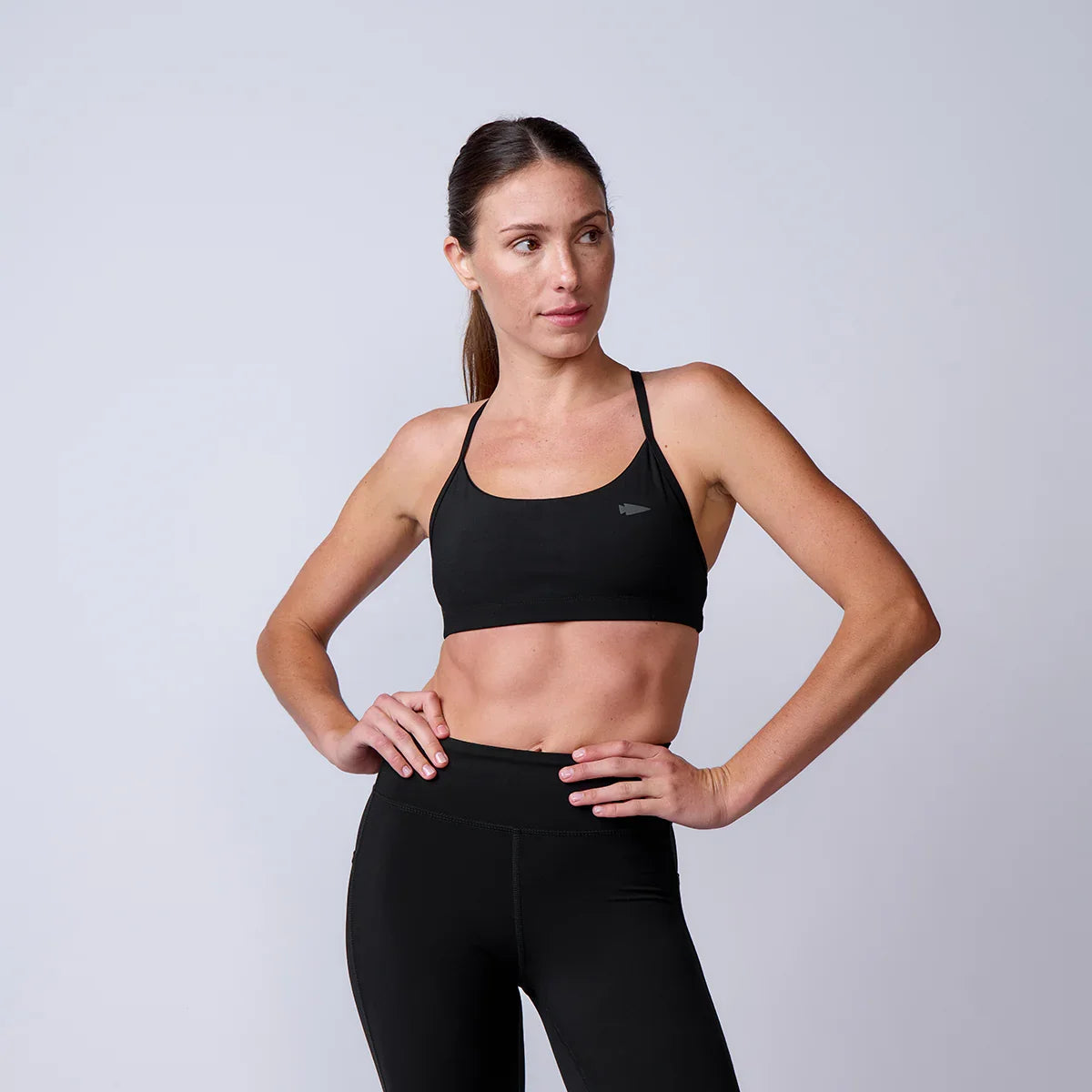 Woman wearing GORUCK black sports bra and leggings, athletic studio apparel