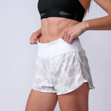 GORUCK athletic woman in camo rucking shorts and black sports bra adjusting waistband