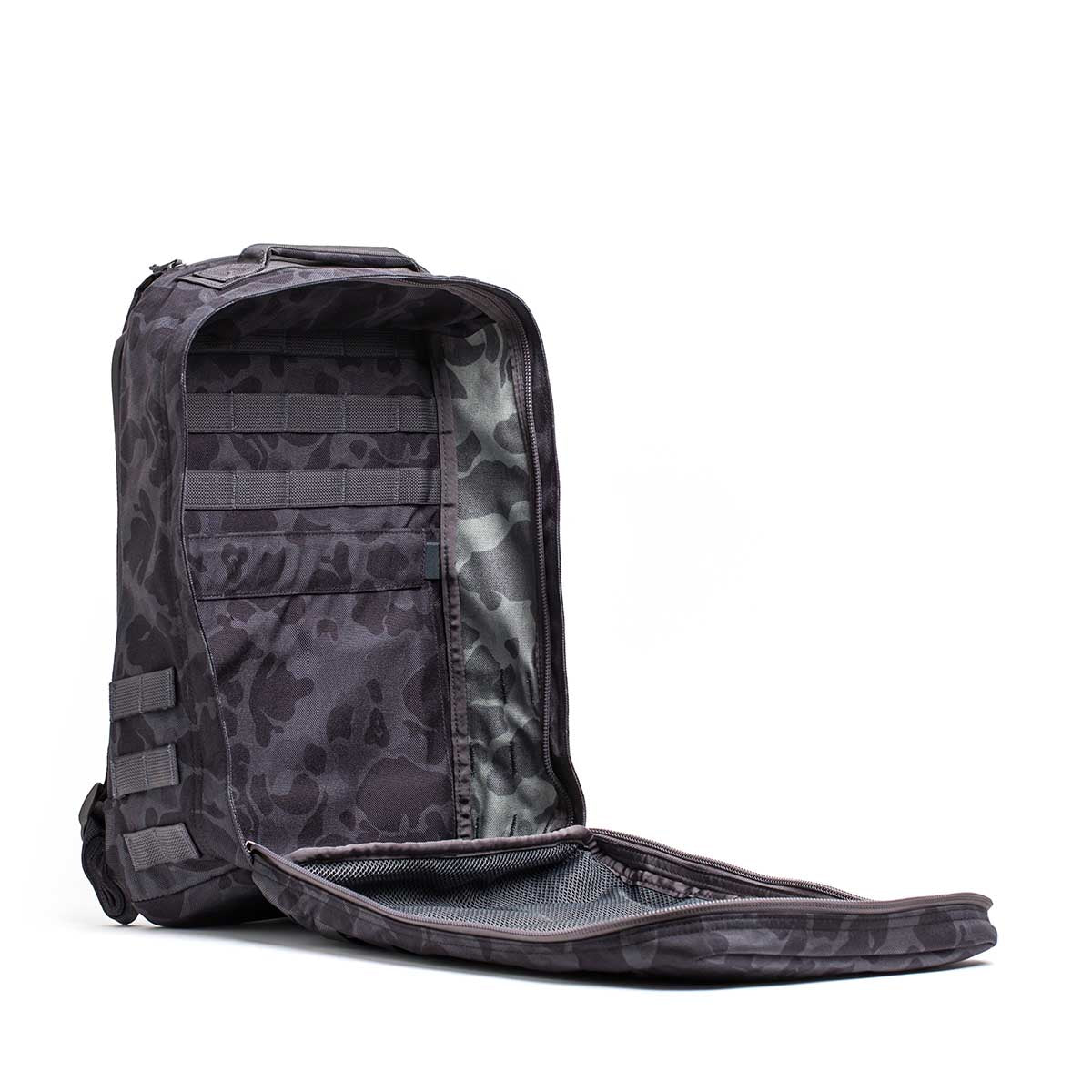 The GR1 rucksack, shown in black camo with its main compartment open and interior mesh pockets visible, is built to Special Forces standards—an example of tough American craftsmanship.