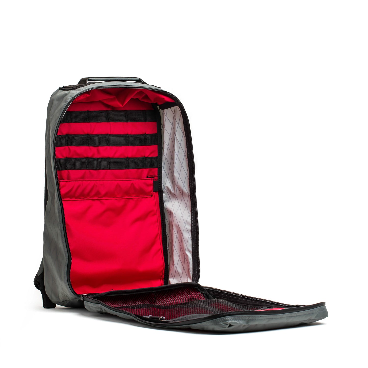 The GR1 USA - Waterproof X-PAC rucksack in gray features unzipped red interior pockets and black elastic straps for organization—ideal as a durable, waterproof gear backpack.
