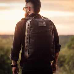 Man outdoors wearing GORUCK rucksack at sunset, rugged durable backpack for rucking gear