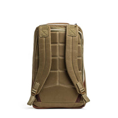 The GR1 USA - Heritage Waxed Canvas backpack in tan is shown from the back, highlighting its padded shoulder straps and quilted back panel.