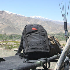 GORUCK black rucksack on stretcher outdoors with mountain landscape background