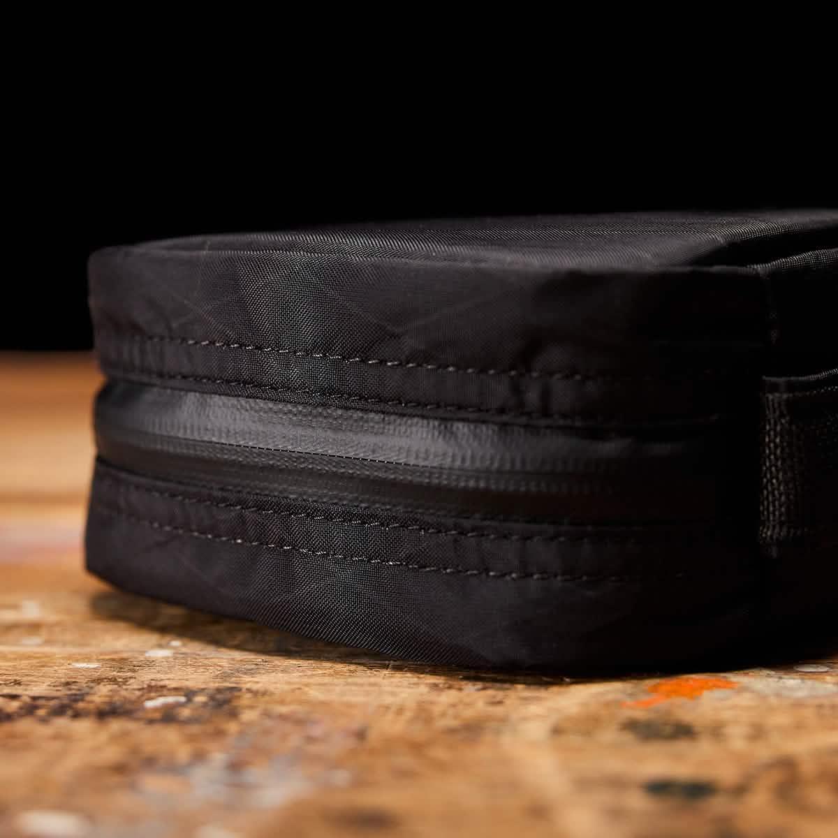 Close-up of GORUCK black rucking gear pouch with zipper on wooden surface