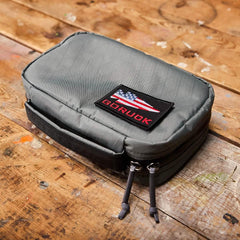 GORUCK gray gear pouch with American flag patch on rustic wooden table