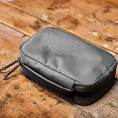 GORUCK rugged gray rucking gear pouch with zippers on wooden surface