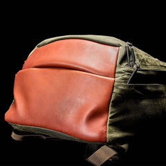 GORUCK olive green and brown rucksack with leather front panel on black background