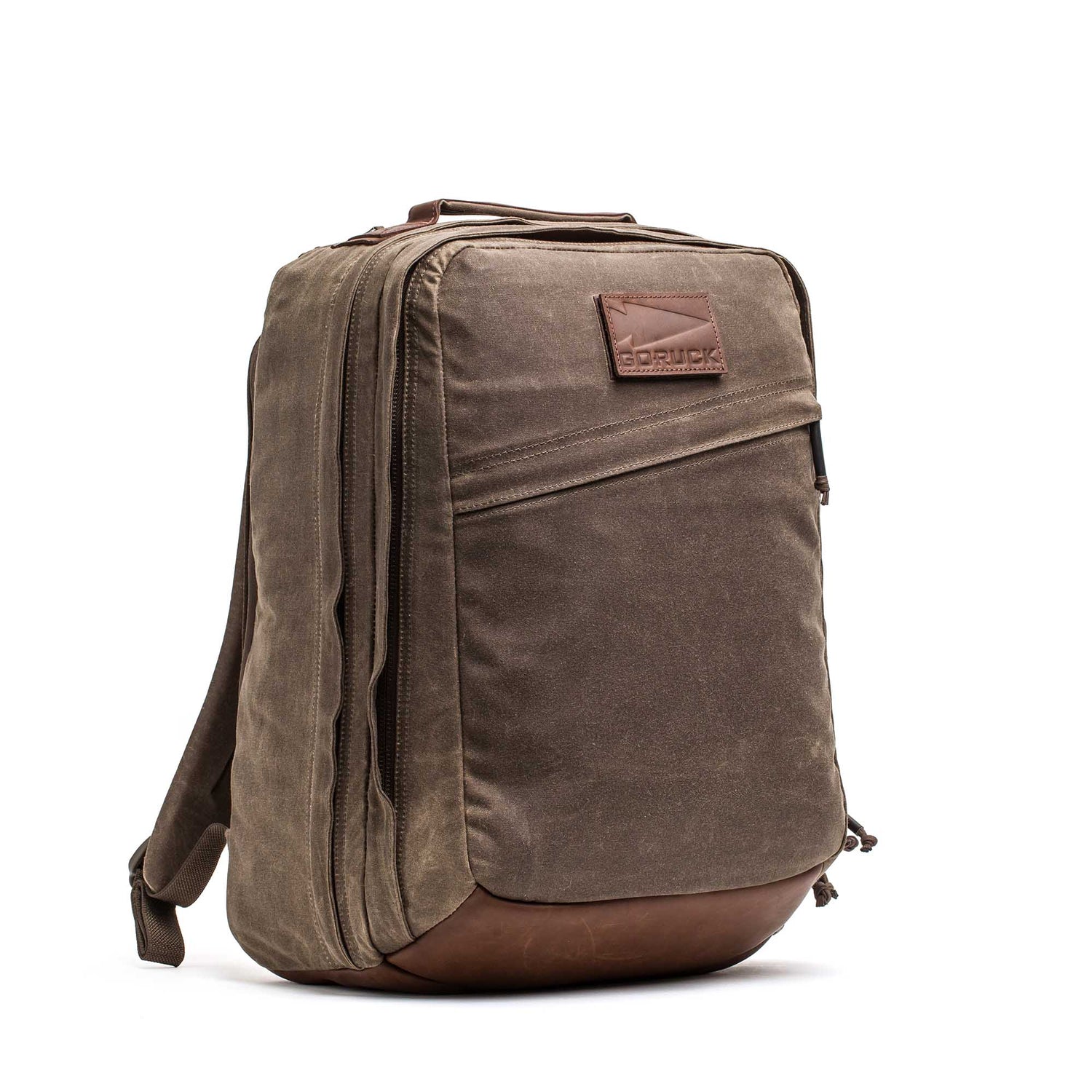 The GR2 - Heritage Waxed Canvas is a brown backpack with leather accents, side zipper pockets, and a top handle, ideal for travel ruck use and shown against a white background.