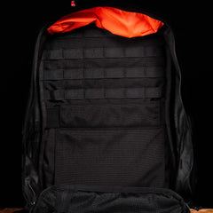 Open GORUCK backpack with black interior, orange lining, and multiple storage compartments