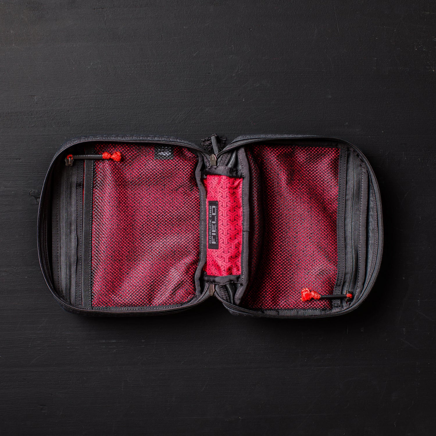 GORUCK red and black zippered field pocket organizer open on black surface
