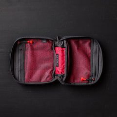 GORUCK red and black zippered field pocket organizer open on black surface