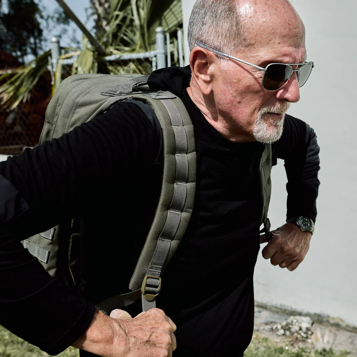 Man wearing GORUCK Ranger Green 40L rucksack outdoors, showcasing durable rucking gear