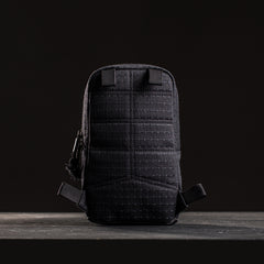 The GRenade x Carryology - GRXC2 Samurai 2.0, a small black tactical pouch with grid stitching and waterproof design, stands upright against a dark background.