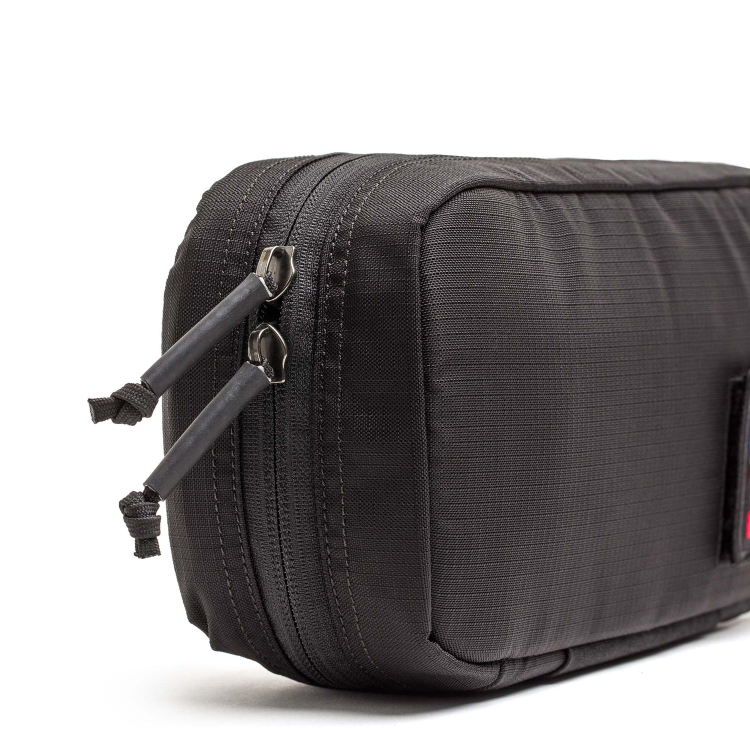 Close-up of a black IFAK pouch by GORUCK featuring two zipper pulls, shown against a white background.