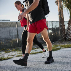 Two people rucking outdoors with GORUCK gear, wearing athletic apparel and backpacks