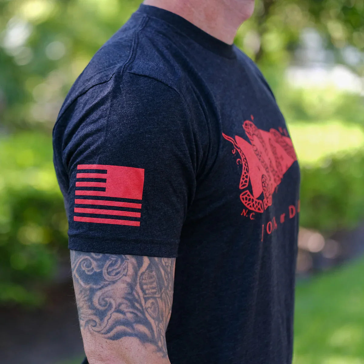 GORUCK black t-shirt with red American flag and Join or Die snake design, worn outdoors