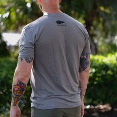 Man outdoors wearing GORUCK grey t-shirt, showing logo and arm tattoos