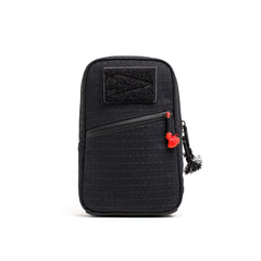 The GRenade x Carryology - GRXC2 Samurai 2.0 is a black zippered pouch with a front pocket, red zipper pull, and black top patch, designed for tactical sling use and enhanced waterproof performance.