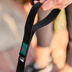 GORUCK black leash with teal logo patch held outdoors, durable rucking gear accessory