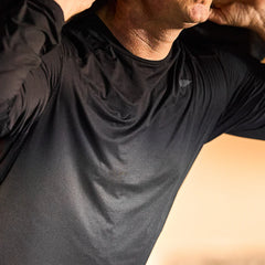 GORUCK black long sleeve performance tee shirt worn by man indoors, close-up view