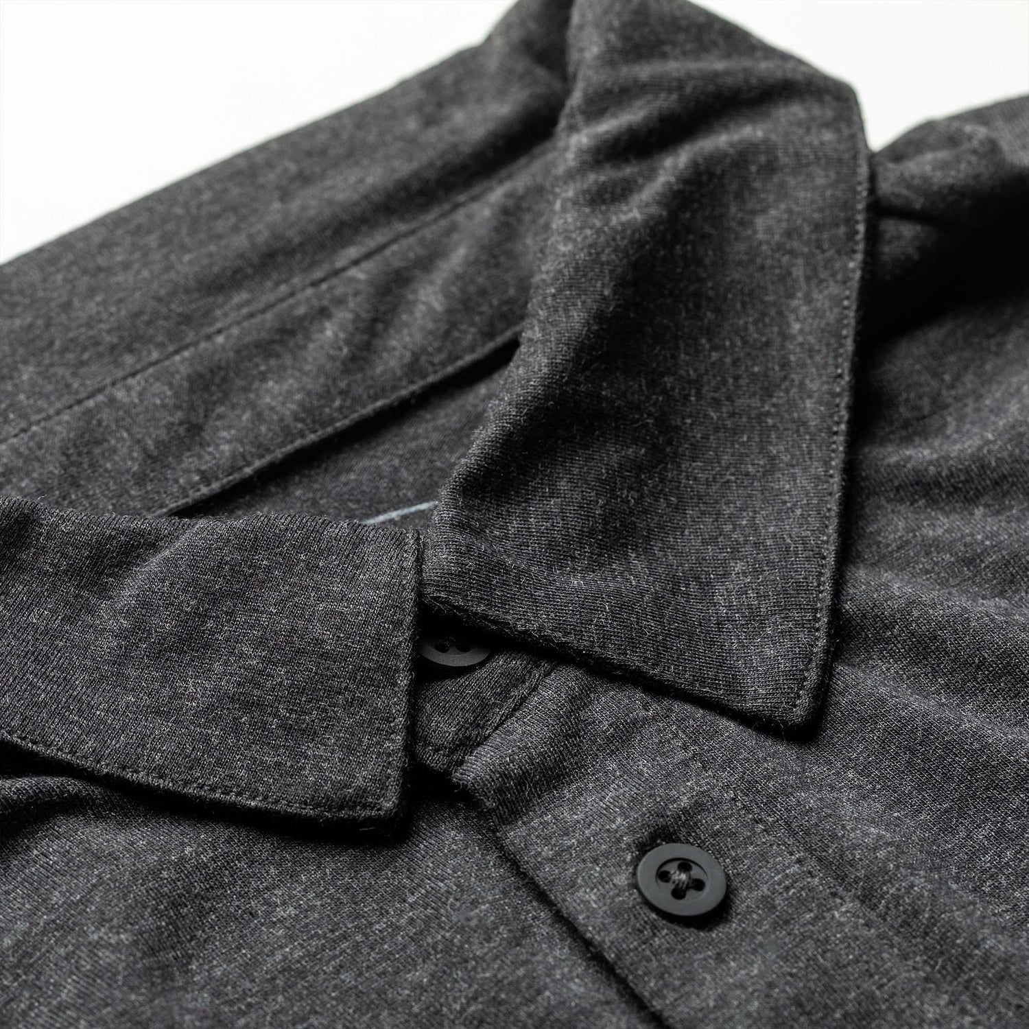 GORUCK men's black triblend polo shirt with pocket and black buttons, close-up view