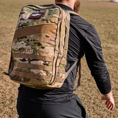 Man wearing black GORUCK long sleeve top with multicam ruck backpack outdoors