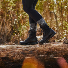 Person wearing charcoal merino wool socks and black boots walking on a log outdoors, GORUCK gear