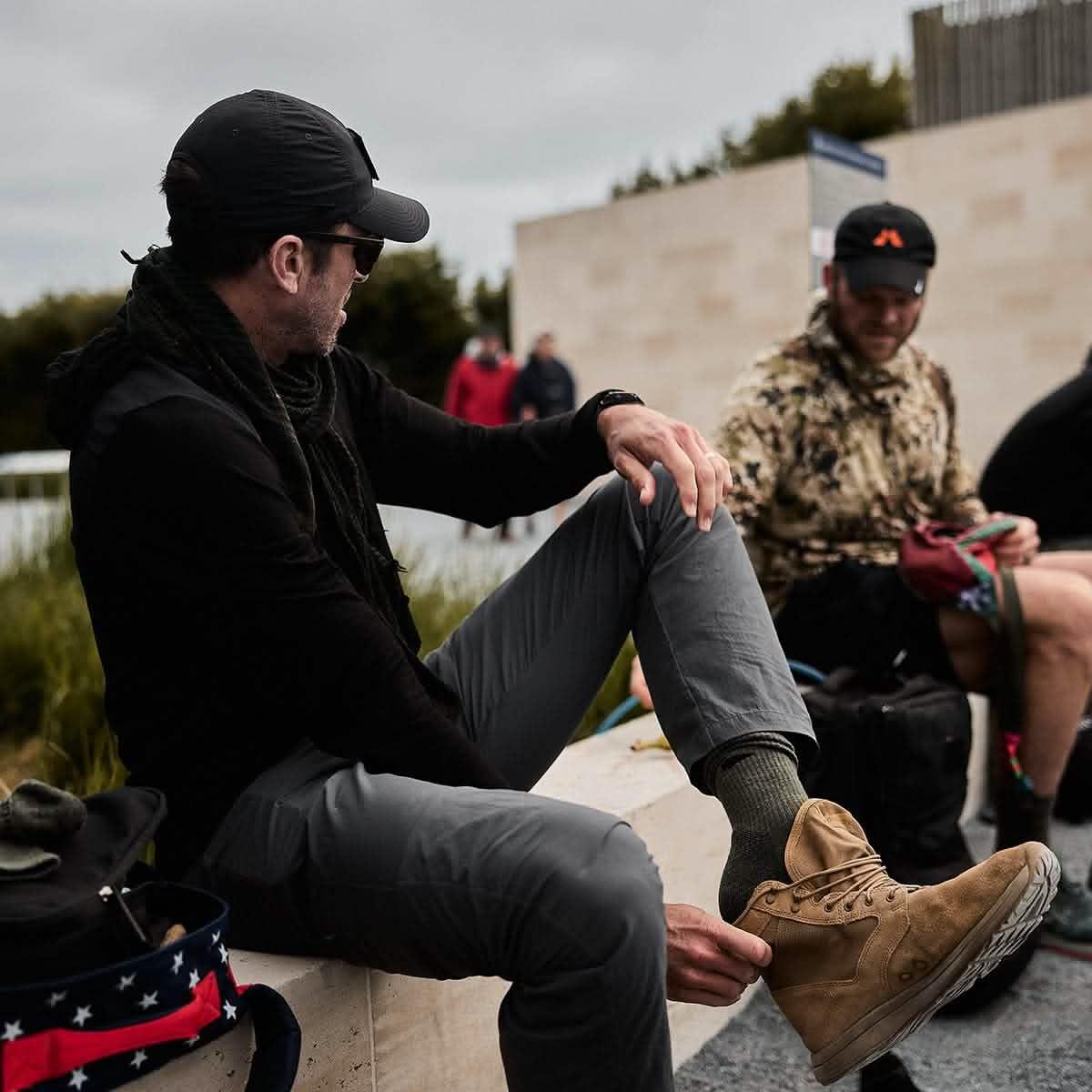 Man outdoors wearing GORUCK Ranger Green Merino Wool Socks and tan rucking boots