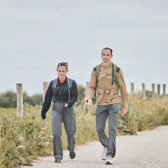 Two people rucking outdoors in GORUCK gear with backpacks on a rural path