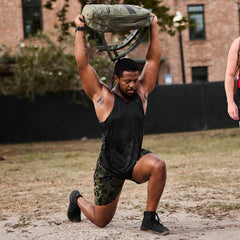 Man performing outdoor ruck workout with GORUCK backpack overhead on one knee