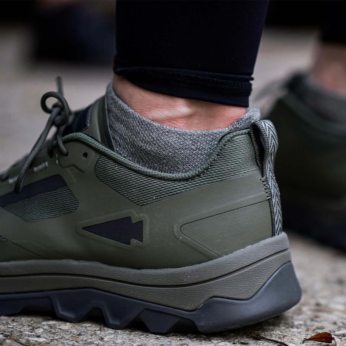 GORUCK no show Merino sock in charcoal, worn with green rucking shoe outdoors