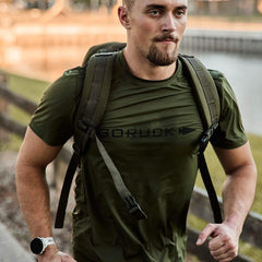 Man rucking outdoors in olive GORUCK Tough Mesh Tee and backpack, fitness gear focus