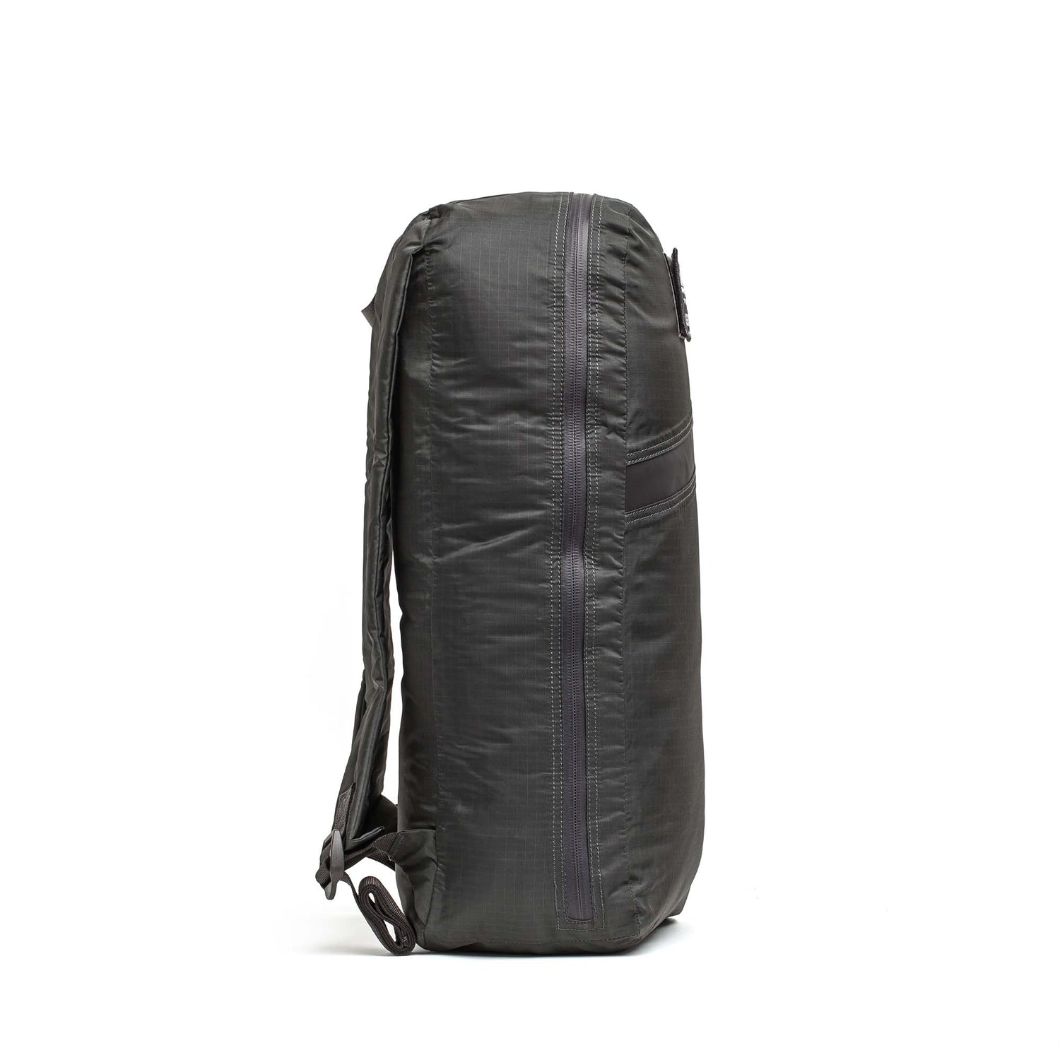Side view of the Packable Bullet Ruck - Ripstop ROBIC® backpack in dark gray, featuring AquaGuard zippers and padded shoulder straps, standing upright.