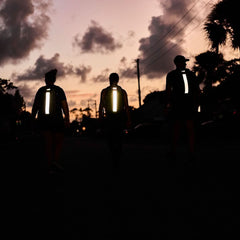 Three people rucking at sunset with GORUCK backpacks featuring reflective strips.